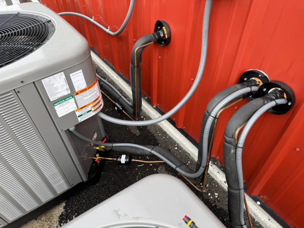 Commercial AC unit refrigerant line penetration and installation in Nicholasville, KY.